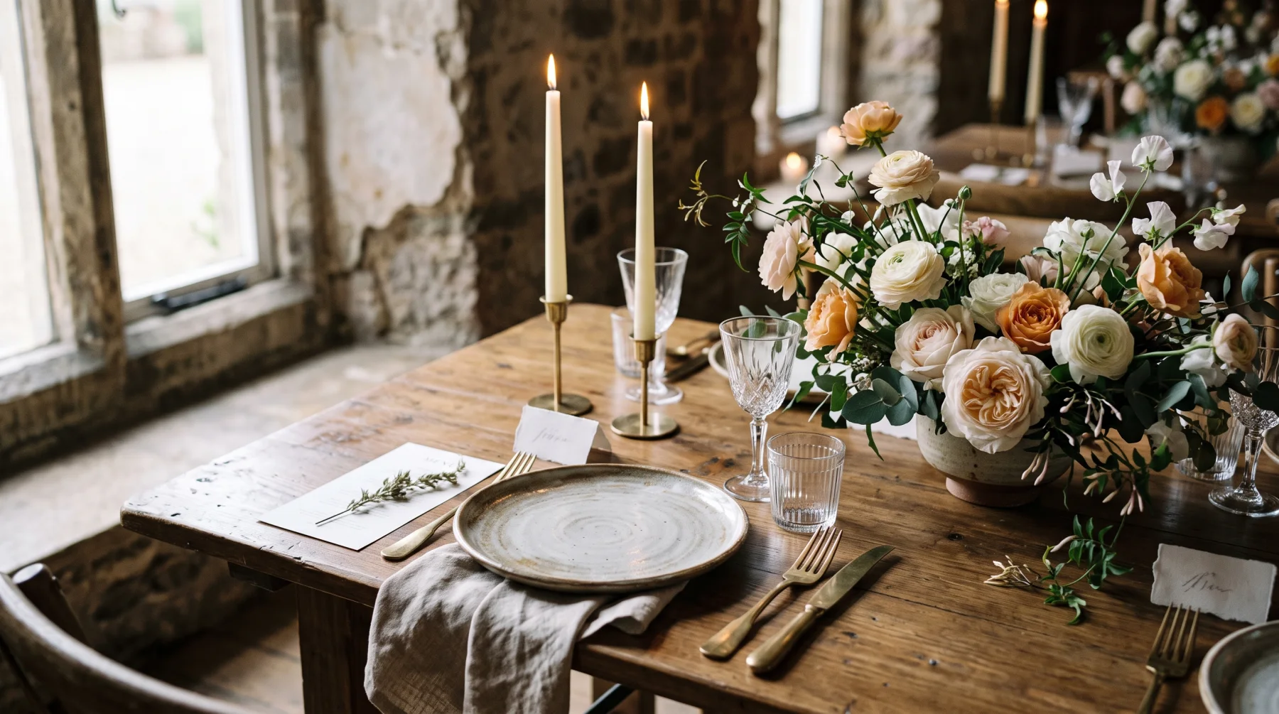 A dressed reception table with candles and garden roses